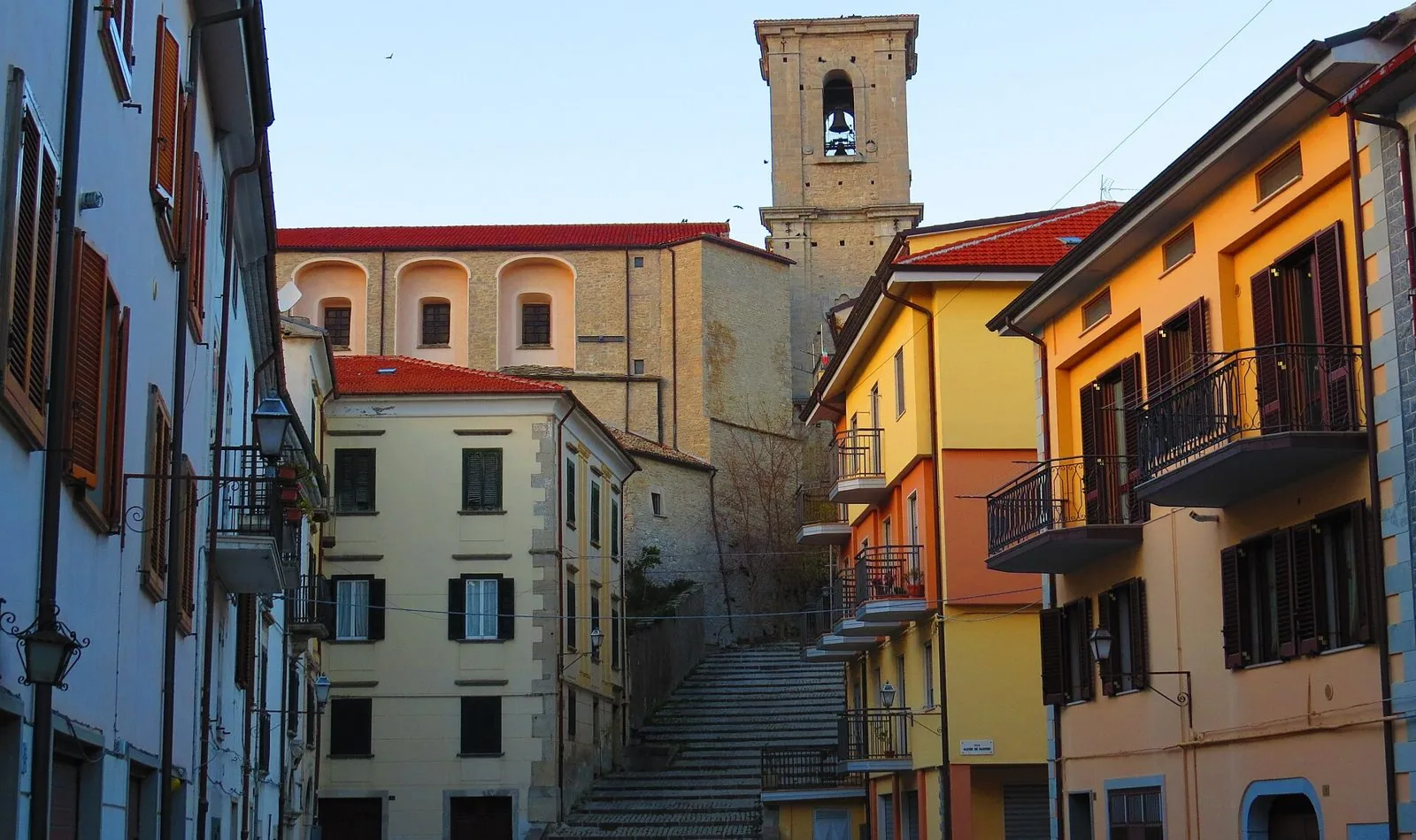 Scorcio del centro storico di Agnone con case colorate, una scalinata in pietra e un campanile sullo sfondo